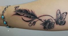 a woman's arm with a feather and rose tattoo on it