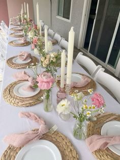 the table is set with white plates and pink napkins