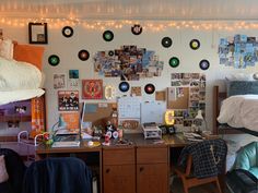 a dorm room with lots of pictures on the wall and lights strung from the ceiling