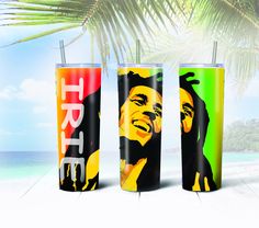 three different colored tumblers sitting next to each other on a beach with palm trees in the background