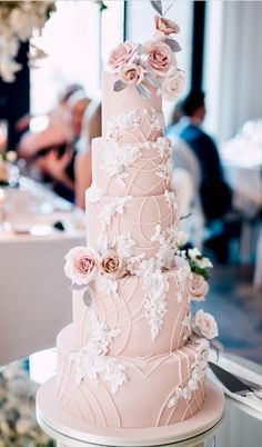 a pink wedding cake with white flowers on it