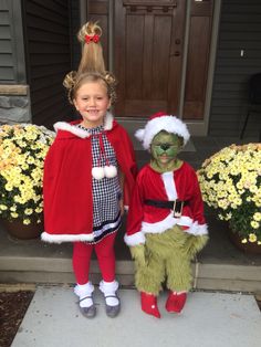 two children dressed up as grinen and the grinet are standing on steps in front of a house