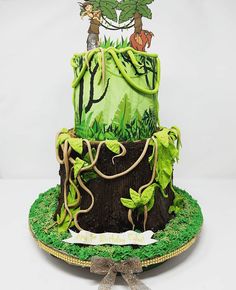 a three tiered cake decorated with trees and plants