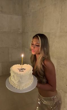 a woman holding a cake with a candle in it