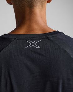 the back of a man wearing a black shirt with silver x on it's chest