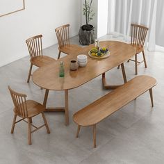 a wooden table with four chairs and a bowl of fruit on the dining room table