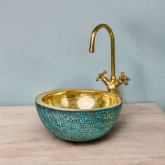 a bathroom sink with a gold faucet and blue speckles