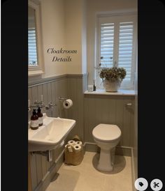 a white toilet sitting next to a sink in a bathroom under a window with shutters