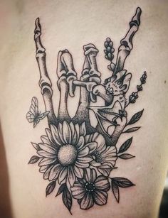 a black and white tattoo design on the back of a woman's shoulder with flowers