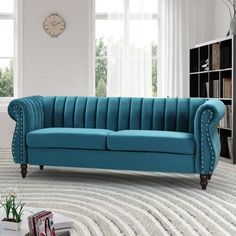 a blue couch sitting on top of a white rug