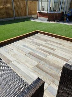 an outdoor patio with grass and wooden decking