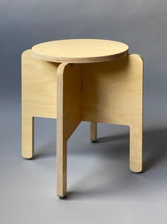 a small wooden table sitting on top of a gray floor