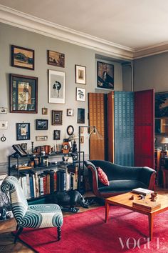 a living room filled with lots of furniture and pictures on the wall above it's bookshelf