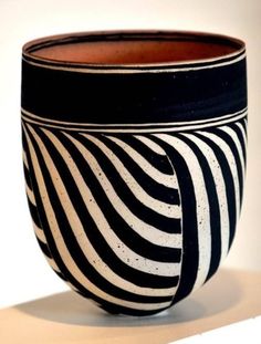 a black and white striped vase sitting on top of a table