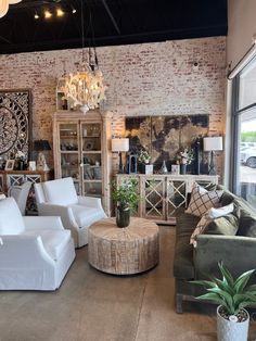 a living room filled with furniture next to a brick wall covered in lights and plants