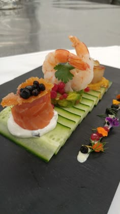 two sushi platters with shrimp and other food items on them, along with garnishes