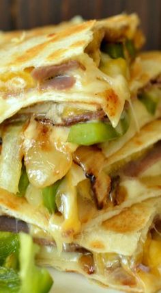 several quesadillas stacked on top of each other with cheese and green peppers