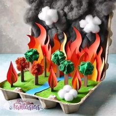 an egg carton filled with fake trees and flames