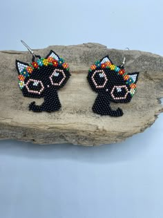 black cat beaded earrings on a rock