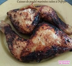 three pieces of chicken sitting on top of a yellow plate with words written in french