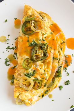 an omelet with peppers and onions on a white plate