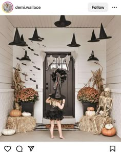 a woman standing in front of a door decorated for halloween