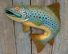 a fish statue on the side of a wooden wall