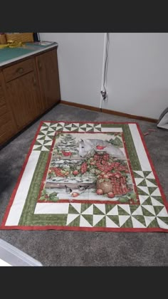 a kitchen area with a quilted table runner on the floor