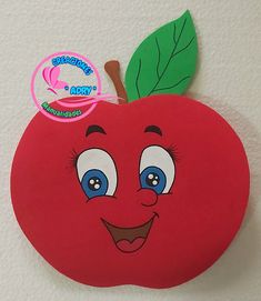 a red apple with blue eyes and a green leaf on it's tip is hanging from the wall