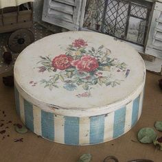 an old white box with flowers painted on it and some scissors laying next to it