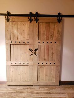 two wooden doors with metal handles in a room