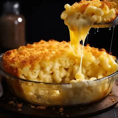 macaroni and cheese being lifted from a casserole dish