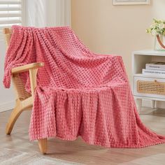 a pink blanket sitting on top of a wooden chair