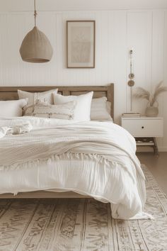 a bed with white sheets and pillows in a room