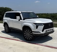 a white suv is parked in an empty lot