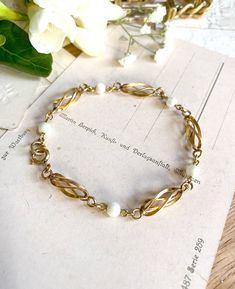 HOLIDAY SHIPPING UPDATE: Please reach out if you'd like me to add expedited shipping before you purchase and I can adjust prices as needed. Happy Holidays & Thank you for visiting us! -Lillian Here is a vintage Gold Filled fancy link chain bracelet. This shiny, chic bracelet has a beautiful texture and looks lovely worn alone or paired with other bracelets. Between the fancy swirl links are small faux pearls that are bright and white. This lovely bracelet has a light, delicate style. This vintag Vintage Formal Chain Bracelet With Polished Finish, Vintage Gold Pearl Bracelet Gift, Luxury Vintage Bracelet With Gold Clasp, Bracelet Fancy, Luxury Vintage Gold-tone Bracelets, Bracelet With Pearls, Art Deco Aesthetic, Luxury Vintage Gold-tone Chain Bracelet, Bracelet Art