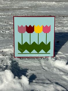 there is a sign with flowers on it in the snow