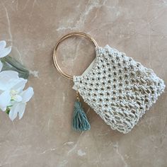 a white crocheted bag with a tassel hanging from it's side