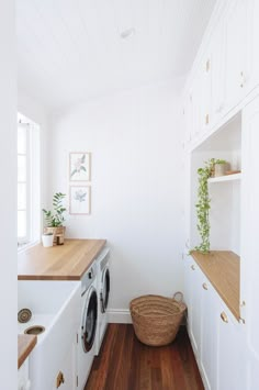 a washer and dryer in a white laundry room with wood flooring on the side