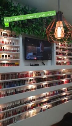 there is a television on the wall in this room with many shelves full of bottles