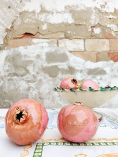 three pink fruit sitting on top of a table