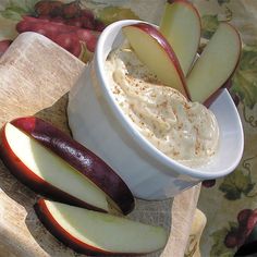 there is an apple and some other food in the bowl next to it on a table