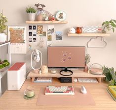 a desk with a computer monitor, keyboard and various office supplies on top of it