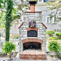 an outdoor fireplace surrounded by potted plants