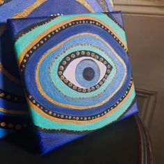 a blue tie with an eye painted on the front and back of it, sitting on top of a table