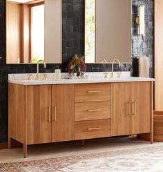 a bathroom vanity with two sinks and mirrors