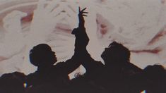 silhouettes of people raising their hands in the air