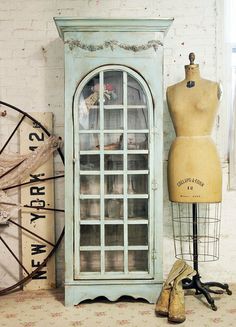 an old china cabinet next to a mannequin's dummy