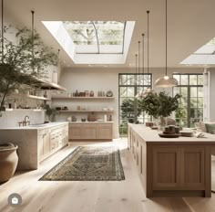 a large kitchen with wooden floors and skylights above the countertop, along with an area rug on the floor