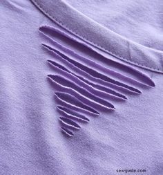 a purple t - shirt with holes in the front and bottom part of it's sleeve